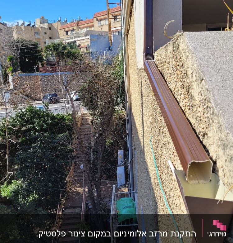 מרזב חום מחובר לגג עם רעפים חומים